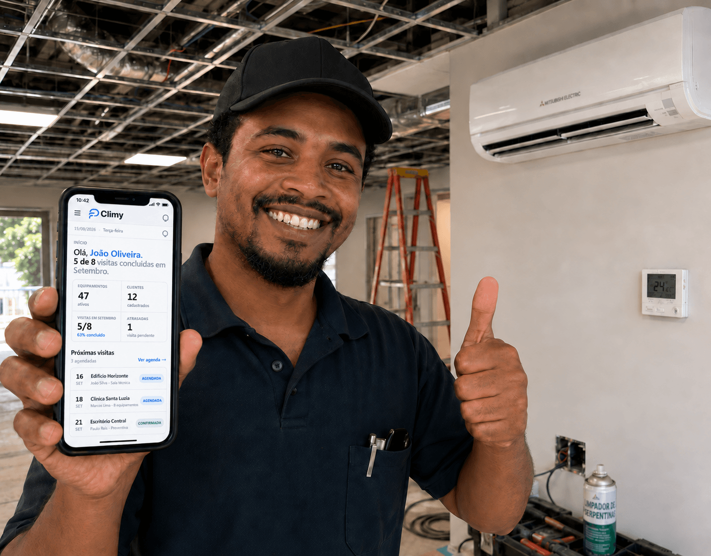 Técnico mostrando a agenda de visitas do Climy no celular, em frente a um split instalado